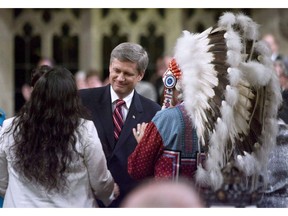 Assembly of First Nations Chief Phil Fontaine, right, watches as Canadian Prime Minister Stephen Harper thanks Beverley Jacobs, then head of the Native Women's Association of Canada, after she responded to the government's apology for more than a century of abuse and cultural loss involving Indian residential schools at a ceremony in the House of Commons June 11, 2008.