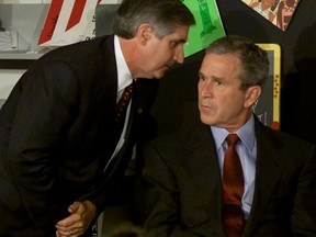 Then-U.S. president George W. Bush listens as chief of staff Andrew Card tells him a second plane has hit the World Trade Center. Bush was reading with children at the Emma E. Booker Elementary School, in Sarasota, Florida at the time of the attack on Sept. 11, 2001.