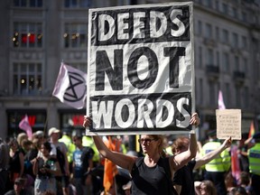 Demonstrators hold placards during an Extinction Rebellion climate activists' protest, at Oxford Circus, in London, Britain, August 25, 2021.