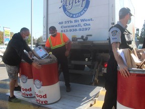 Agape Centre food bank driver Gerry Brown (orange vest) getting help picking up barrels of food donations at FreshCo at midday on Friday. Photo on Friday October 8, 2021 in Cornwall, Ont.