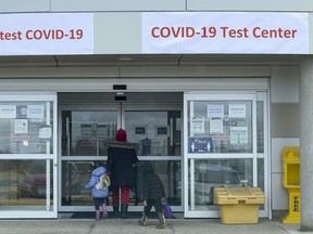 A woman with two children enters the a COVID-19 Test Centre in Ottawa.