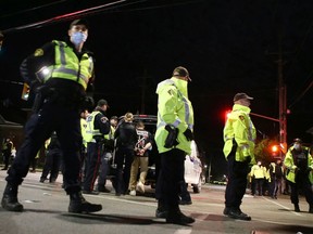 Police place a man in a prisoner transport van after a disturbance at the intersection of Johnson Street and University Avenue Saturday as thousands of students celebrated Queen's University homecoming in Kingston, Ont. on Saturday, Oct. 16, 2021.

Elliot Ferguson/The Whig-Standard/Postmedia Network