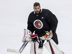 Ottawa Senators goaltender Matt Murray heads to the bench to have his mask repaired during team practice at the Canadian Tire Centre, Oct. 13, 2021.