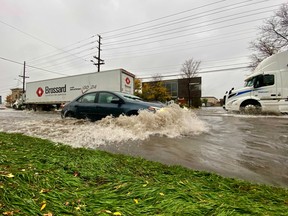 Traffic plows through water in heavy rain conditions on Industrial Avenue Saturday morning