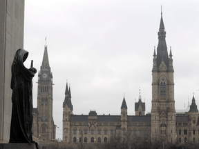 A statue representing justice looks out from the Supreme Court of Canada over the Parliamentary precinct in Ottawa. There is a strong feeling, even among MPs who are vaccinated, that mandatory vaccination is an infringement on freedom of movement and the constitutional rights of Canadians.