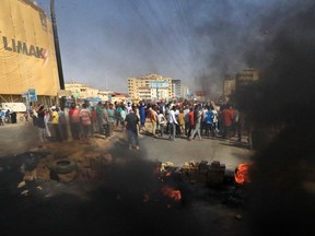 TOPSHOT - Sudanese protesters use bricks and burning tires to block 60th Street in the capital Khartoum, to denounce overnight detentions by the army of members of Sudan's government, on October 25, 2021.