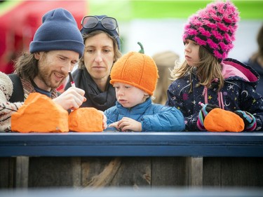 The Tagwàgi Festival, the first in a series of four seasonal events that will take place at Mādahòkì (to share the land) Farm, the National Capital Region's new Indigenous attraction and gathering place, was held Sunday, Oct. 17, 2021. Miceal Galagher, Emily Pearlman, five-year-old Orlaith and three-year-old Llewyn were writing on reconciliation rocks that were then placed along a special legacy trail.