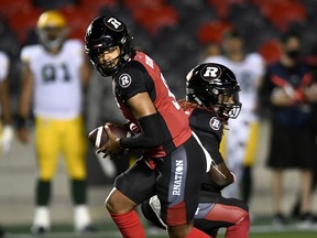 Ottawa Redblacks quarterback Caleb Evans (5) holds the ball from running back Timothy Flanders (20) during first half CFL football action against the Edmonton Elks in Ottawa on Tuesday, Sept. 28, 2021.