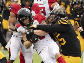 Ottawa Redblacks running back Brendan Gillanders (25) is tackled by Hamilton Tiger Cats defensive end Julian Howsare (95) during first half CFL football game action in Hamilton, Ont., Saturday, Oct. 23, 2021.