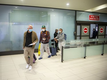 The first international flight since the pandemic began, a flight from Fort Lauderdale, Fla., landed at the Ottawa International Airport on Sunday, Oct. 31, 2021. Travellers Ron, Paris and Devon Axam come through the COVID-19 testing area as they return to Ottawa after visiting family.