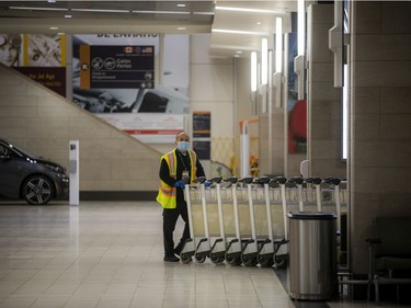 An employee collects the carts at the Ottawa International Airport on Sunday, Oct. 31, 2021.