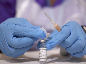 FILE PHOTO: A medical worker prepares an injection with a dose of Astra Zeneca coronavirus vaccine, at a vaccination centre in Baitul Futuh Mosque, amid the outbreak of coronavirus disease (COVID-19), in London, Britain, March 28, 2021. REUTERS/Henry Nicholls/File Photo