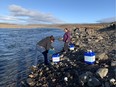 Residents collect water from the Sylvia Grinnell River near Iqaluit, Nunavut on Wednesday, Oct. 13, 2021 after potential petroleum was discovered in the city's tap water, making it undrinkable.