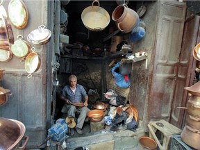 A coppersmith sits in his shop in the ancient city of Fez, Morocco October 16, 2021. Picture taken October 16, 2021.