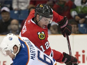 Chicago Blackhawks forward Kyle Beach, right, gets the puck past Edmonton Oilers centre Ryan Martindale during the first period of an NHL pre-season hockey game in Saskatoon on Tuesday, Sept 20, 2011.