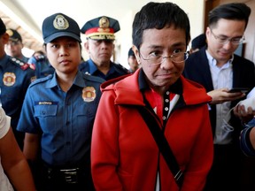 FILE PHOTO: Rappler CEO and Executive Editor Maria Ressa is escorted by police after posting bail in Pasig Regional Trial Court in Pasig City, Philippines, March 29, 2019.