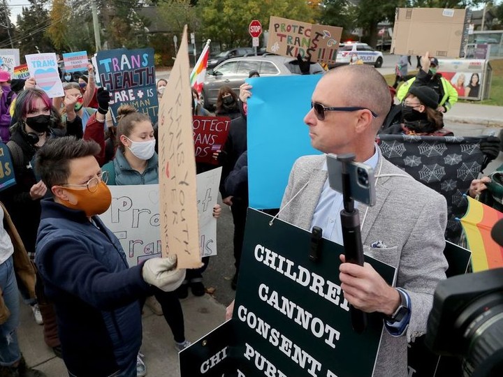  Ottawa city councillor Catherine McKenney (orange mask) and others voice their counter-protest against the protest of Chris Elston, right, on Tuesday morning.