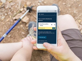 A handout image from what3words shows an unidentified individual using the what3words mobile app. The string of words "reaction.waiters.down" is the designation for the app and an online mapping site for a 3x3-metre spot near Anmore, B.C., north of Vancouver. Credit: