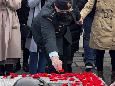 A member of the Canadian Armed Forces places a poppy on the Tomb of the Unknown Soldier following Remembrance Day services at the National War Memorial on Thursday, Nov. 11, 2021