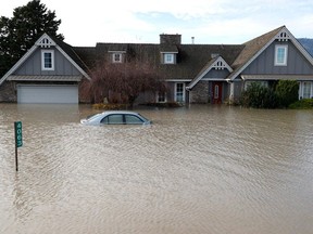 A home and car sit submerged in floodwaters on Nov. 21, 2021 in Abbotsford, British Columbia. Residents and farmers continue to clean up and recover nearly a week after the Canadian province of British Columbia declared a state of emergency. Now, new rainstorms are forecast.