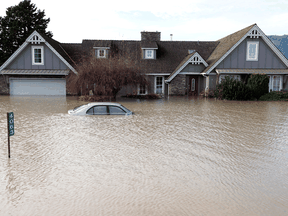 A home and car sit submerged in floodwaters on November 21, 2021 in Abbotsford, British Columbia.
