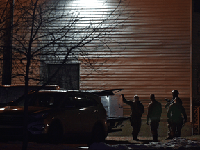 A police tactical unit stands outside a building during a hostage situation in Edmonton on November 29, 2021.