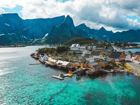 The Lofoten archipelago in northern Norway is mountainous, with deep fjords and calm ocean waters.