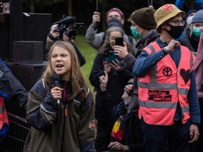 Greta Thunberg, Swedish environmentalist, left, speaks at a Fridays for Future protest at Festival Park during the COP26 climate talks in Glasgow, U.K., on Monday, Nov. 1, 2021.