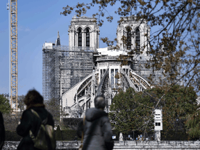 People look at Notre-Dame de Paris cathedral during the reconstruction work, on April 14, 2021 — a day before the two year anniversary of a fire that severely damaged the building.