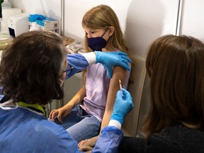 A girl receives her first shot of the corona vaccine in Vienna, Austria on November 15, 2021. - Authorities began vaccinating children between five and 11 against coronavirus in the capital on Monday among soaring rates that saw a country wide lockdown for some two million people who have not been fully vaccinated against COVID-19.