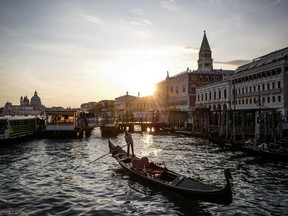 A gondola sails at sunset on the Grand Canal in front of the Palazzo Ducale — Doge's Palace — in Venice. The Venice Biennale, held in one of the world's most remarkable cities, is a unique opportunity to showcase and celebrate art and architecture.