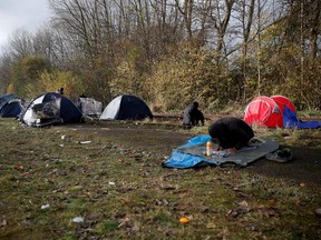 A migrant prays at a makeshift migrant camp in Loon Beach, the day after 27 migrants died when their dinghy deflated as they attempted to cross the English Channel, in Dunkerque near Calais, France, November 25, 2021.