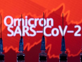 Syringes with needles are seen in front of a displayed stock graph and words "Omicron SARS-CoV-2" in this illustration taken on Nov. 27, 2021. REUTERS/Dado Ruvic/Illustration