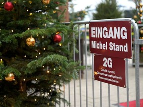 A '2G' rule sign, allowing only those vaccinated or recovered from the coronavirus disease (COVID-19) to enter indoor areas, is displayed at the entrance of a booth at a Christmas market in Hamburg, Germany, November 16, 2021.