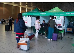 Passengers queue to get a PCR test against the coronavirus disease (COVID-19) before traveling on international flights, at O.R. Tambo International Airport in Johannesburg, South Africa, November 26, 2021. REUTERS/Sumaya Hisham