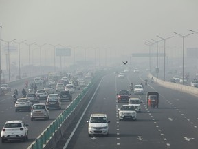 Vehicles are seen shrouded in smog on a highway in New Delhi, India, November 18, 2021.