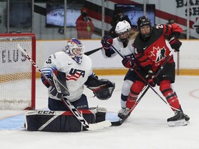 Canada's National Women's hockey team took on United States during first period action at TD Place in Ottawa Tuesday. Natalie Spooner from Team Canada fights for position with Caroline Harvey in front of United States goalie Maddie Rooney on Tuesday.