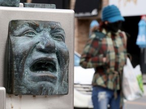 Not everyone is happy that the colder winter weather is on its way as pedestrians get bundled up while walking on Elgin Street in Ottawa Wednesday.