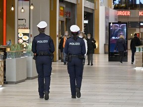 Austrian police officers patrol during a control in a shopping mall in Voesendorf, district Moedling, Austria, on November 16, 2021, during the ongoing coronavirus (COVID-19) pandemic.