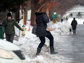 Two women approach the walk along Fourth Avenue differently on Tuesday: one navigating the icy sidewalk, while the other just opts for the road.