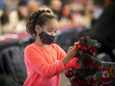 Eight-year-old Kaylina Hodgins-Small works on decorating her Christmas tree in the crafts area during Saturday's event.