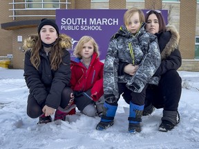 Christine Moulaison, co-chair of the Ottawa Carleton Assembly of School Councils, along with three of her children, Chloe, 12, Bear, 8, and Jack, 6, in front of South March Public School, which the boys attend.