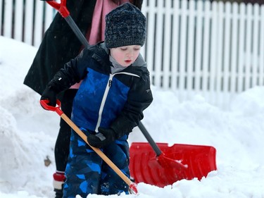 Claire Christie gets some help from her three-year-old Alec as the pair use a couple of shovels to dig out Monday morning.
