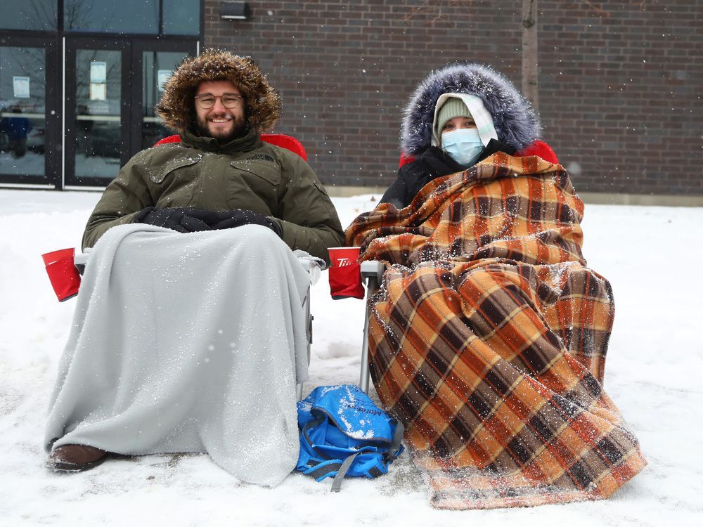Eric Dobbins and Marjorie Lapierre brought chairs while waiting in the line up for free COVID rapid tests at the Barrhaven Minto Centre in Ottawa, December 22, 2021.