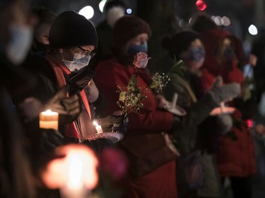 People held candles and roses at the annual memorial service in Minto Park to mark the National Day of Remembrance and Action on Violence Against Women on Monday, Dec. 6, 2021.