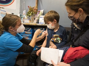 Five-year-old Charlie Berry, alongside mom Brie Ostler, receives his first dose of a COVID-19 vaccine from Dr. Nili Kaplan-Myrth on Nov. 26, 2021.