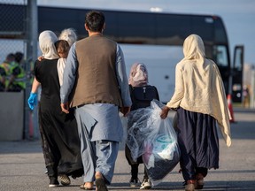 Files: Afghan refugees who supported Canada's mission in Afghanistan prepare to board buses after arriving in Canada, at Toronto Pearson International Airport August 24, 2021.