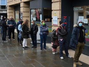 People wait in a queue outside a pop-up vaccination centre for the COVID-19 vaccine or booster, in Hammersmith and Fulham in Greater London on December 3, 2021, as rollout accelerates in England.