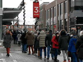 People line up outside an Ottawa hockey arena to receive their COVID-19 booster shots, Monday, Dec. 20, 2021.