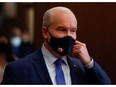 Canada's Conservative Party leader Erin O'Toole removes his mask as he speaks after the throne speech last month.